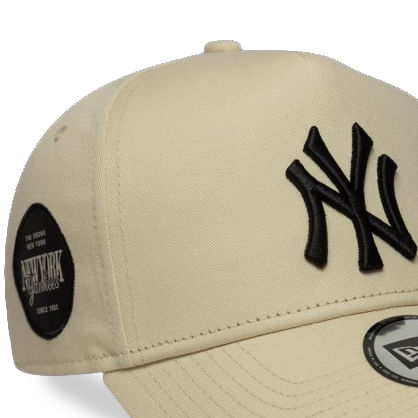 Boné New Era New York Yankees bege, close lateral esquerda mostrando bordado e textura do tecido